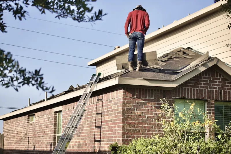 Professional roofer working on a residential roof in Broadalbin